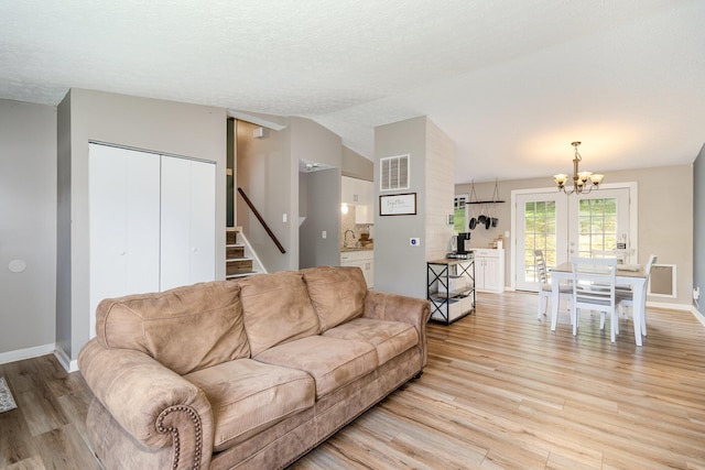 30 Valeside Dr, Covington, KY 41017 - living room with a chandelier, light wood-style floors, stairs, lofted ceiling, and a textured ceiling