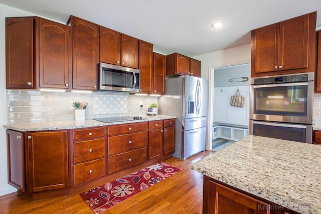 800 Buck Ct, Erlanger, KY 41018 - kitchen featuring appliances with stainless steel finishes, wood finished floors, light stone counters, tasteful backsplash, and recessed lighting