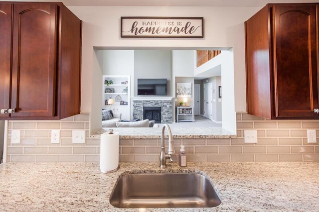 800 Buck Ct, Erlanger, KY 41018 - kitchen featuring light stone countertops, tasteful backsplash, a stone fireplace, and open floor plan