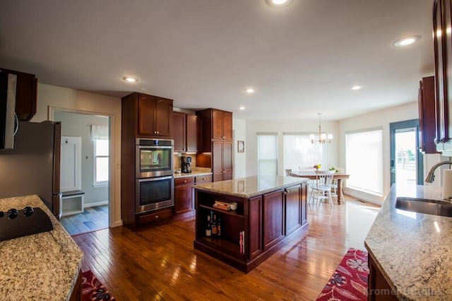 800 Buck Ct, Erlanger, KY 41018 - kitchen with appliances with stainless steel finishes, dark wood-type flooring, a chandelier, light stone countertops, and recessed lighting