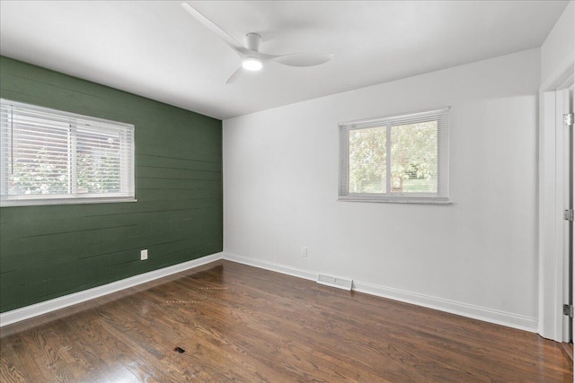 695 Maple Tree Ln, Erlanger, KY 41018 - unfurnished room featuring plenty of natural light, a ceiling fan, dark wood-style floors, and wooden walls