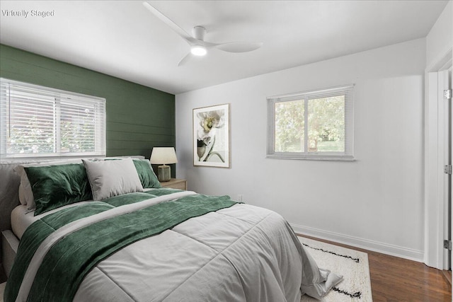 695 Maple Tree Ln, Erlanger, KY 41018 - bedroom with multiple windows, an accent wall, wood finished floors, and a ceiling fan
