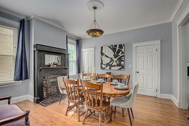 3141 Beech Ave, Covington, KY 41015 - dining area featuring crown molding, light wood-style floors, and a premium fireplace