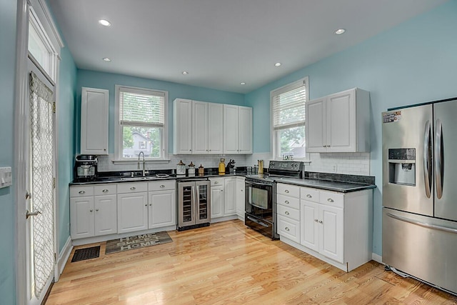 3141 Beech Ave, Covington, KY 41015 - kitchen featuring stainless steel refrigerator with ice dispenser, black / electric stove, beverage cooler, dark countertops, and decorative backsplash