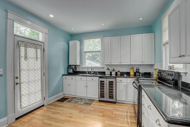 3141 Beech Ave, Covington, KY 41015 - kitchen with black electric range, beverage cooler, plenty of natural light, decorative backsplash, and recessed lighting