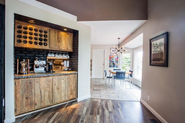 108 Regency Ct, Highland Heights, KY 41076 - bar with dark wood-style flooring, a chandelier, and hanging light fixtures