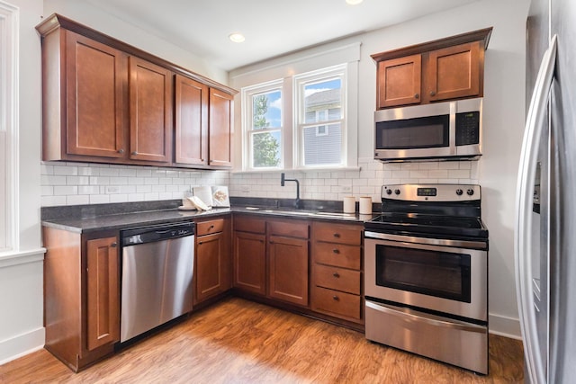 343 Rossford Ave, Fort Thomas, KY 41075 - kitchen with stainless steel appliances, dark countertops, light wood finished floors, decorative backsplash, and recessed lighting