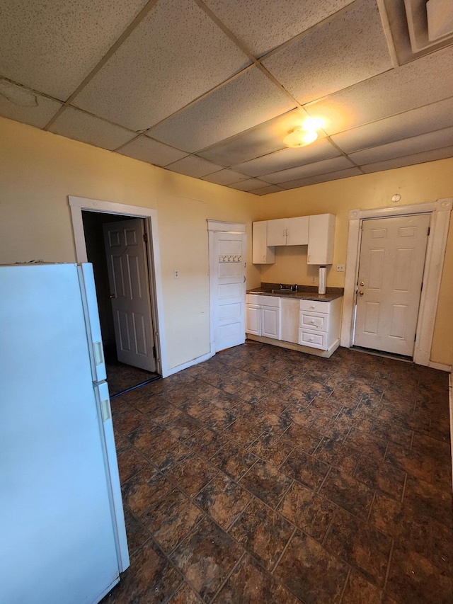 1539 Wheeler Aly, Covington, KY 41014 - kitchen featuring freestanding refrigerator, white cabinetry, dark countertops, and a paneled ceiling