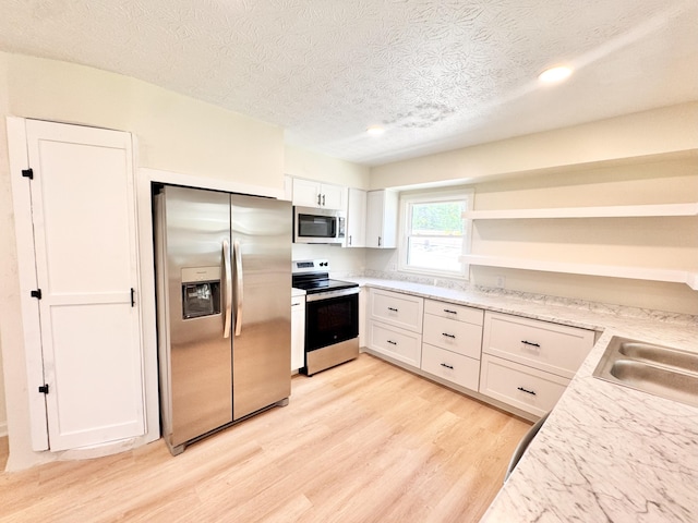 13165 Burns Rd, California, KY 41007 - kitchen with stainless steel appliances, open shelves, light wood-style floors, a textured ceiling, and white cabinetry