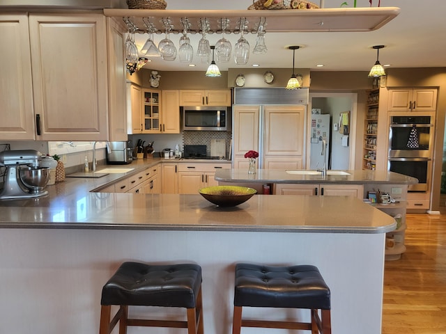 5809 Taylor Mill Rd, Covington, KY 41015 - kitchen featuring appliances with stainless steel finishes, a breakfast bar area, light wood-style floors, and a peninsula