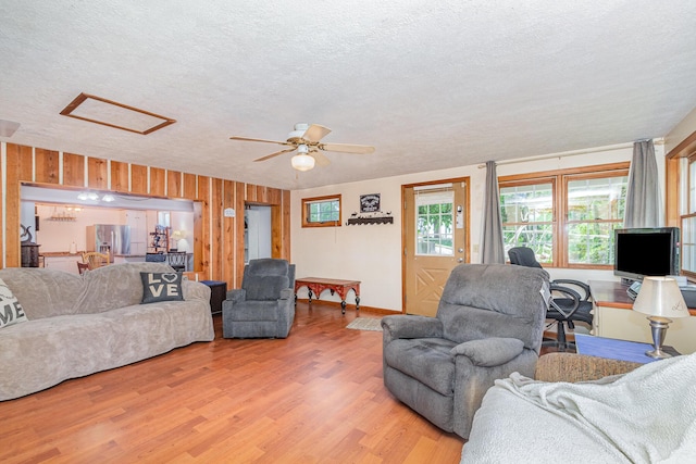 575 Sugar Creek Rd, Dry Ridge, KY 41035 - living room with attic access, a textured ceiling, light wood-style flooring, a ceiling fan, and wooden walls