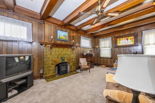 321 6th Ave, Dayton, KY 41074 - living area featuring a wood stove, carpet floors, wood walls, beamed ceiling, and ceiling fan