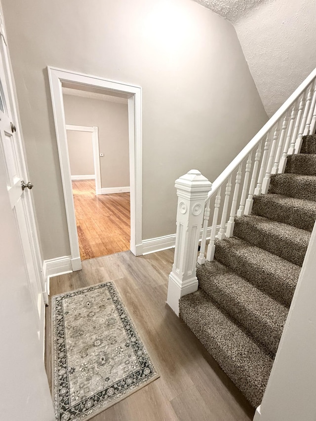 626 W 12th St, Covington, KY 41011 - stairway featuring wood finished floors and a textured ceiling