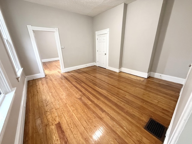 626 W 12th St, Covington, KY 41011 - empty room with light wood-style floors and a textured ceiling
