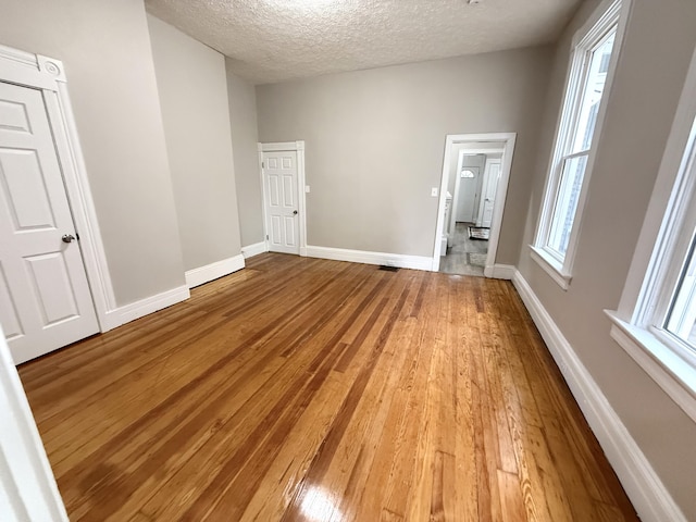626 W 12th St, Covington, KY 41011 - unfurnished bedroom featuring light wood-type flooring and a textured ceiling