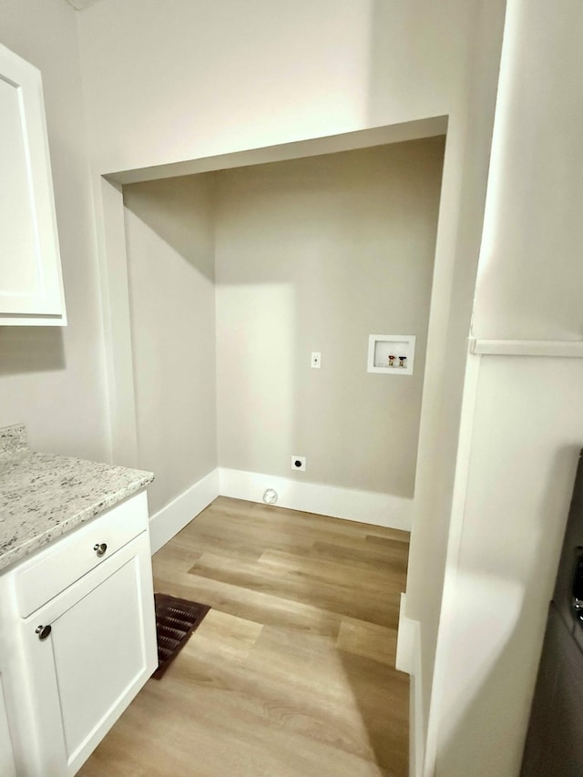 626 W 12th St, Covington, KY 41011 - washroom featuring washer hookup, light wood-type flooring, and cabinet space