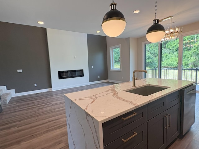 888 Belle Ridge Loop, Bellevue, KY 41073 - kitchen with wood finished floors, stainless steel dishwasher, hanging light fixtures, light stone counters, and a center island with sink