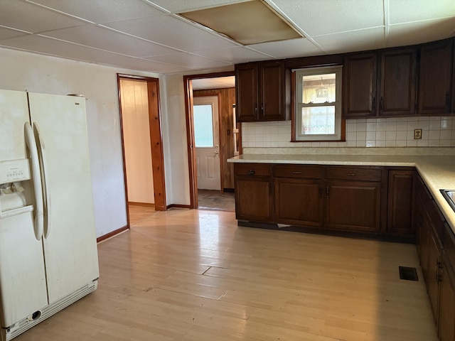 617 Woolery St, Falmouth, KY 41040 - kitchen with white fridge with ice dispenser, light wood-style flooring, light countertops, tasteful backsplash, and dark brown cabinetry