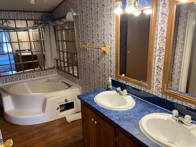 113 Lynn Ln, Falmouth, KY 41040 - bathroom with wallpapered walls, a garden tub, double vanity, and wood finished floors