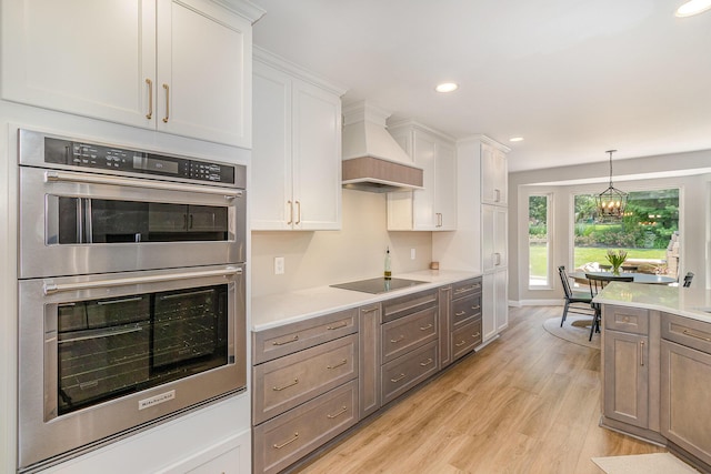 1312 Deer Hollow Ct, Hebron, KY 41048 - kitchen featuring double oven, light wood-type flooring, light countertops, custom exhaust hood, and white cabinets