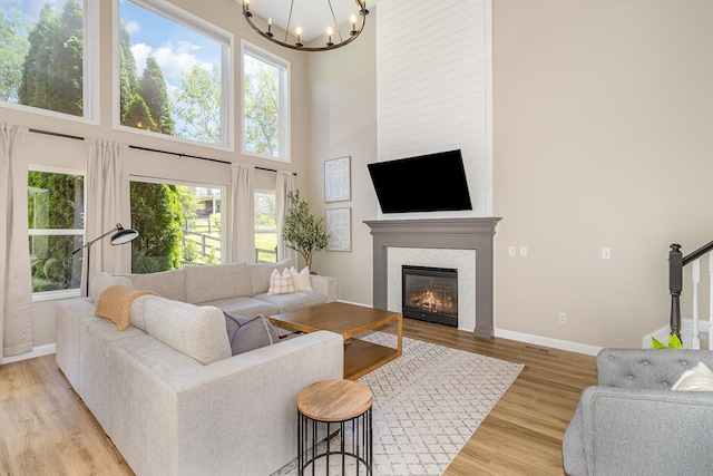 1312 Deer Hollow Ct, Hebron, KY 41048 - living room with a chandelier, plenty of natural light, light wood-type flooring, a large fireplace, and a towering ceiling