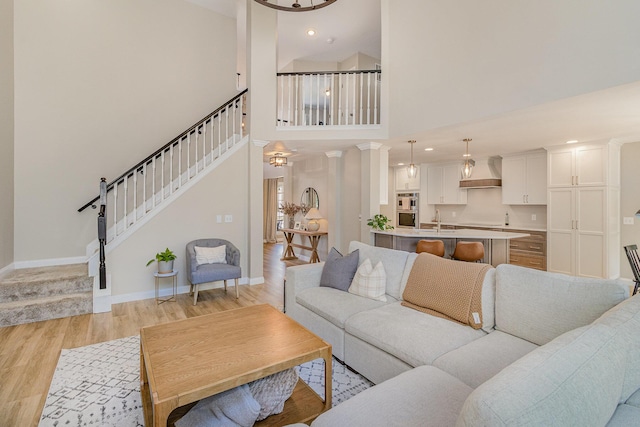 1312 Deer Hollow Ct, Hebron, KY 41048 - living room featuring light wood-style floors, stairway, a high ceiling, and recessed lighting