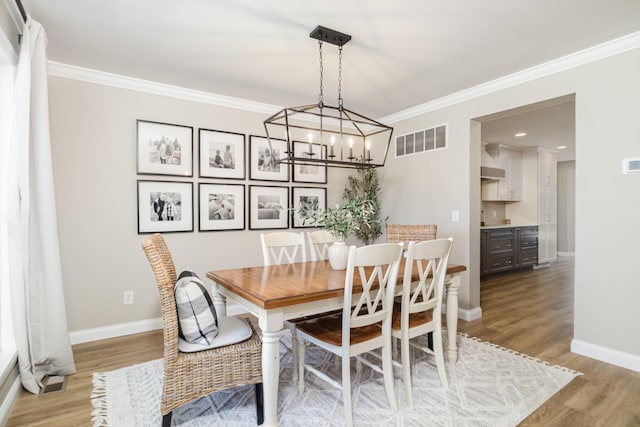 1312 Deer Hollow Ct, Hebron, KY 41048 - dining space featuring light wood finished floors, ornamental molding, and a chandelier