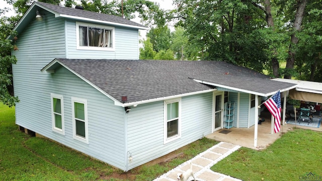 rear view of property with a patio and a lawn