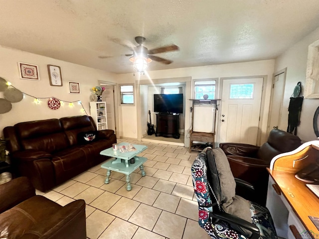 tiled living room featuring ceiling fan, plenty of natural light, and a textured ceiling