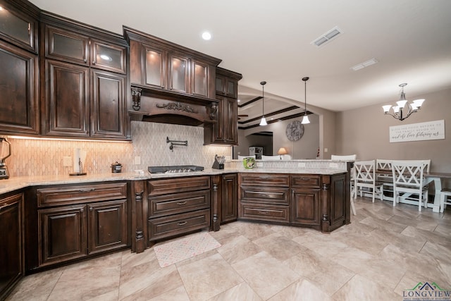 kitchen featuring kitchen peninsula, pendant lighting, and dark brown cabinets