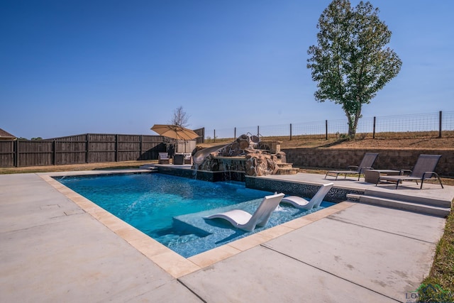 view of pool featuring a patio area, pool water feature, and a hot tub