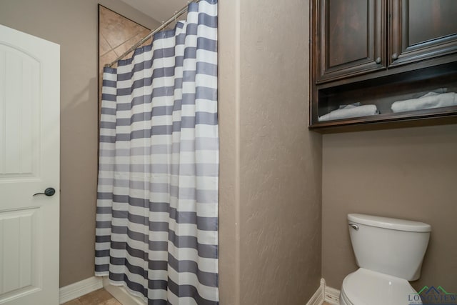 bathroom with a shower with shower curtain and toilet