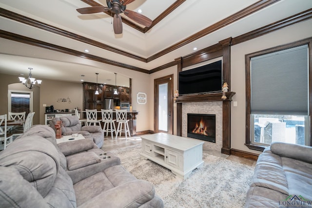 living room with a fireplace, ceiling fan with notable chandelier, ornamental molding, and light tile patterned flooring