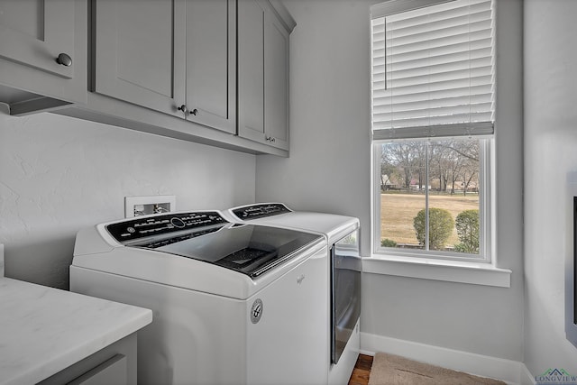 laundry area with washer and dryer, cabinet space, and baseboards