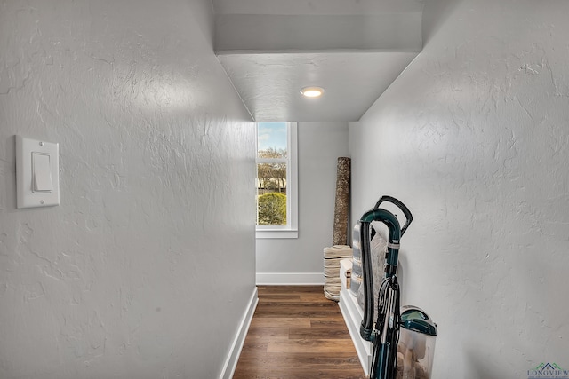 interior space with baseboards, dark wood-style flooring, and a textured wall