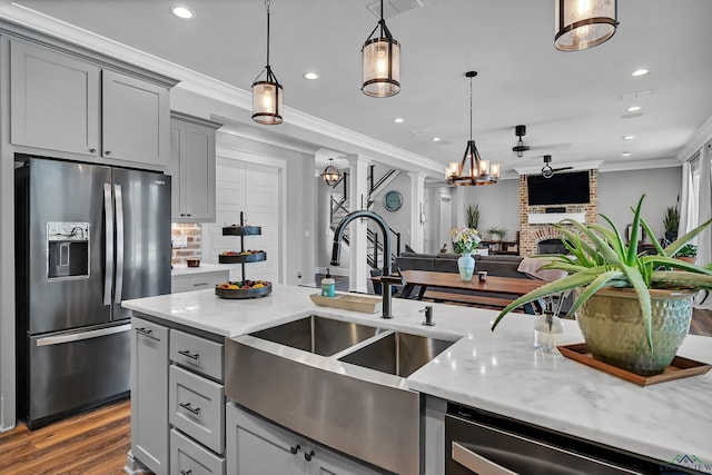 kitchen featuring a sink, crown molding, gray cabinets, and stainless steel appliances