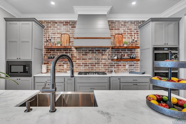 kitchen featuring open shelves, gray cabinetry, appliances with stainless steel finishes, and crown molding