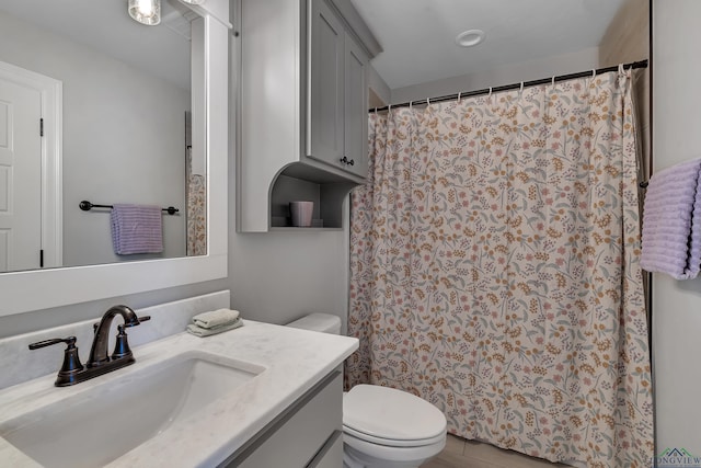 bathroom with a shower with shower curtain, toilet, and vanity