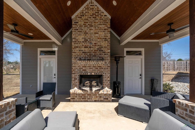 view of patio with an outdoor living space with a fireplace, fence, and ceiling fan