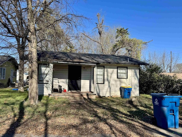 rear view of property featuring a lawn