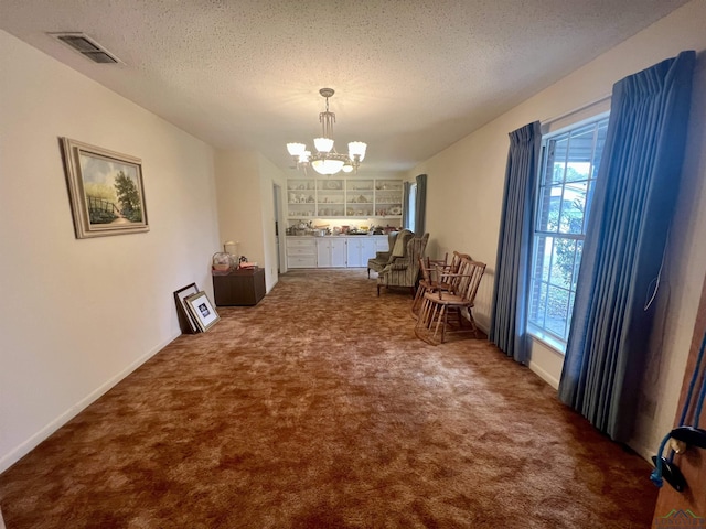 interior space with a textured ceiling and a notable chandelier