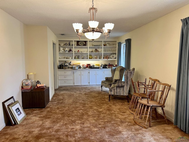 sitting room with carpet, a notable chandelier, and a textured ceiling