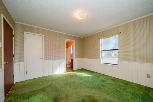 unfurnished bedroom with connected bathroom, carpet floors, and ornamental molding