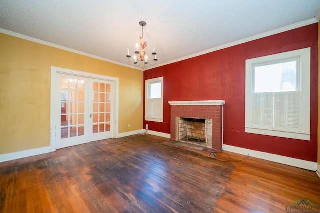 unfurnished living room with wood-type flooring, a brick fireplace, french doors, and crown molding