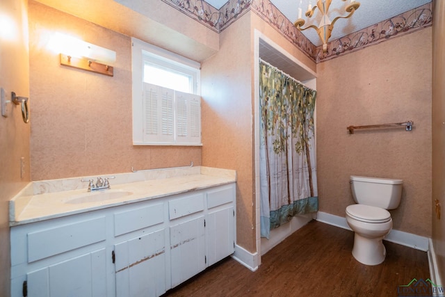 bathroom with hardwood / wood-style floors, vanity, toilet, and walk in shower