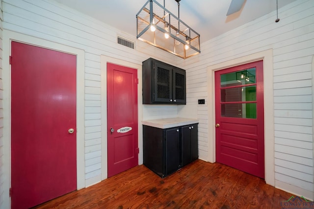 kitchen featuring decorative light fixtures, wood walls, dark hardwood / wood-style floors, and ceiling fan