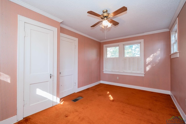 carpeted empty room with a textured ceiling, ceiling fan, and crown molding