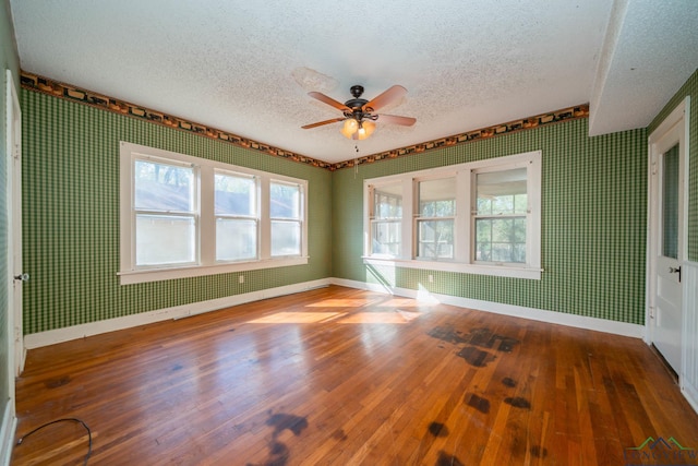 unfurnished room with ceiling fan, hardwood / wood-style floors, and a textured ceiling