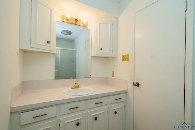 bathroom with vanity and a shower with door