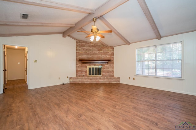 unfurnished living room with hardwood / wood-style floors, lofted ceiling with beams, a brick fireplace, and ceiling fan